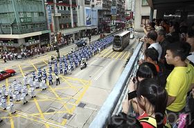 二零一一年国殇日，八百多名法轮功学员的游行队伍在天国乐团的领头下，由长沙湾游乐场出发，途经九龙多个繁华街道，大批人潮在马路两旁观看拍照。