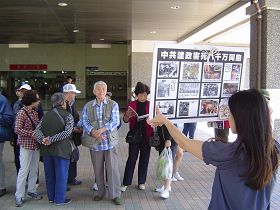 游客观看展板，或阅读真相资料