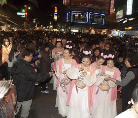 法轮功学员组成的仙女队伍深受市民的喜欢，大家争先恐后领取系有小莲花的“法轮大法好”书签