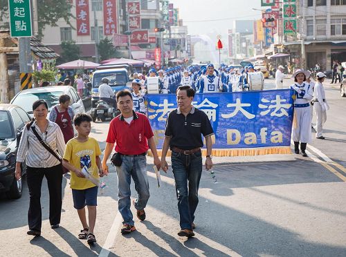 '甲仙区区长李元新（前排右一）与商圈理事长（前排右二）为法轮功队伍踩街开路，赞叹法轮功对观光客吸引力特别强，活络地方经济。'