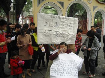 二零一四年三月十六日，邓彩娟的母亲在佛山市中山公园门前为女儿诉冤。