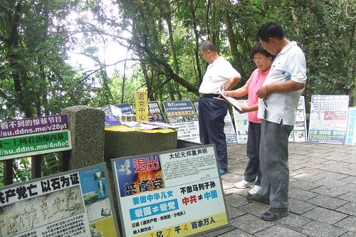 图1：玉尾（中）在玄光寺青龙步道上给大陆游客讲述法轮功无辜遭受中共迫害的真相。