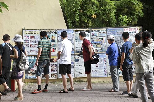 在很多大陆游客登阶梯到英国领事馆参观前也有一排法轮功真相展板，很吸引路过游客观看了解真相。