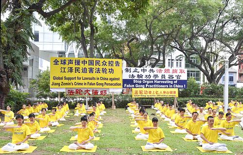 图1：二零一五年十一月一日，新加坡法轮功学员在芳林公园集会，揭露中共江氏集团迫害法轮功的罪行，并征集签名刑事举报江泽民。图为法轮功学员正在演示第五套功法——神通加持法。