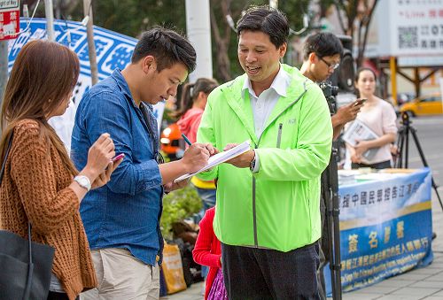 图1：十二月六日，国际人权日前夕法轮功学员于高雄市博爱路、裕诚路口举办举报联署活动，声援中国民众控告江泽民活动”。