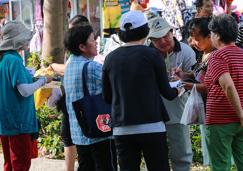 高雄市法轮功学员设展位向民众征签，制止中共迫害法轮功，民众响应热烈。了解真相的人们纷纷签名，期盼早日将恶人绳之以法。