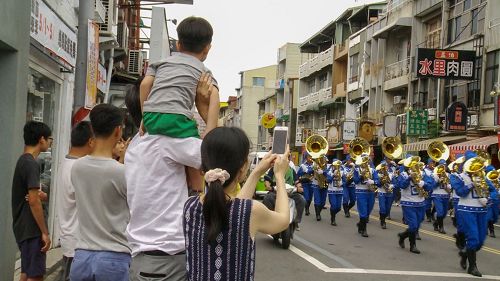 '图3：很多市民拿手机争相对着行进中的天国乐团拍照。'