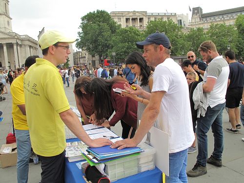 图1～4：二零一八年六月九日，英国法轮功学员在伦敦特拉法加北台阶炼功、讲真相。