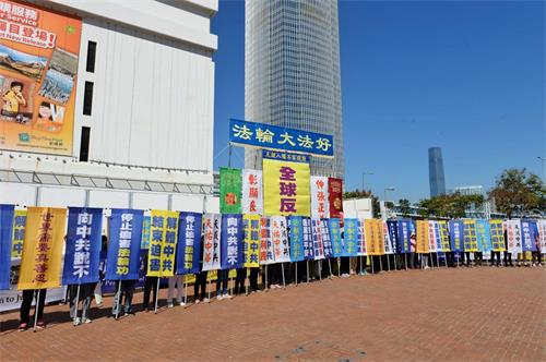 '图2：法轮功学员在集会上展示各式幡旗，呼吁三退保平安，以及法办元凶、解体中共。'