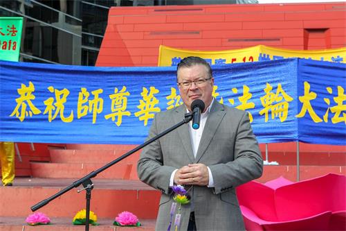 '图1：二零一九年五月十一日，在墨尔本市中心女王桥广场（Queensbridge Square）举行的庆祝法轮大法洪传世界二十七周年庆典上，维州自由党上议院资深议员、反对党党鞭伯尼·菲恩（Bernie Finn MP）先生发言敬贺。'