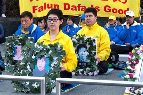 今年四月二十日，法轮功学员王易非手持被迫害致死的妹妹王可非的遗像