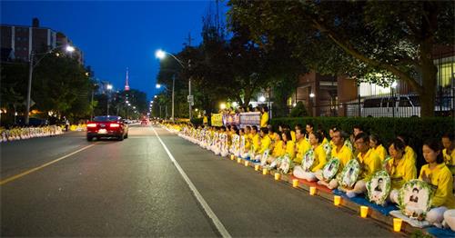 '图1～3：夜幕渐渐降临，法轮功学员安静祥和肃穆的场面，吸引不少来往民众驻足关注和了解真相。有过往的车辆慢慢停下来录像，有司机询问要资料，许多路人纷纷用手机记录，并支持法轮功学员反迫害，还有大陆民众现场三退。'