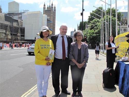 '图11：帕特里克·格雷迪国会议员（Patrick Grady MP）在法轮功学员“反迫害二十年”集会现场与来自他选区的法轮功学员合影'