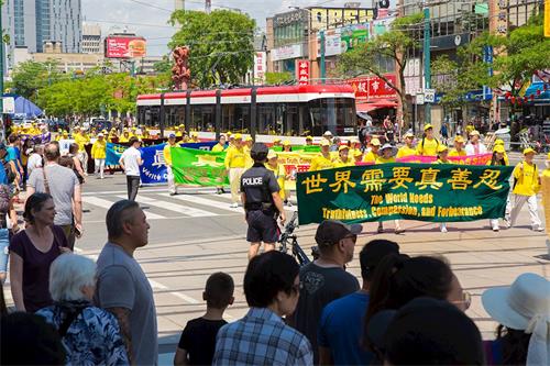 '图3：2019年7月20日，加拿大东部法轮功学员汇集多伦多市中心，举行盛大游行，纪念反迫害20周，呼吁中共停止对法轮功修团体的迫害。'