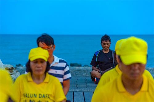 '图7：台东法轮功反迫害烛光悼念，路过民众主动与法轮功坐在一起，表达支持。'