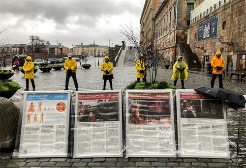 '图2：二零二零年十一月二十日风雨交加，讲真相活动如往常一样进行，学员们伴随着炼功音乐在雨中展示功法'