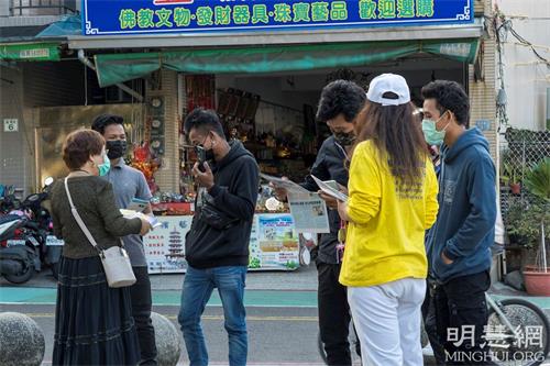 '图8：四位年轻人很高兴接受真相资料，并拿起手机拍下炼功的祥和画面。'