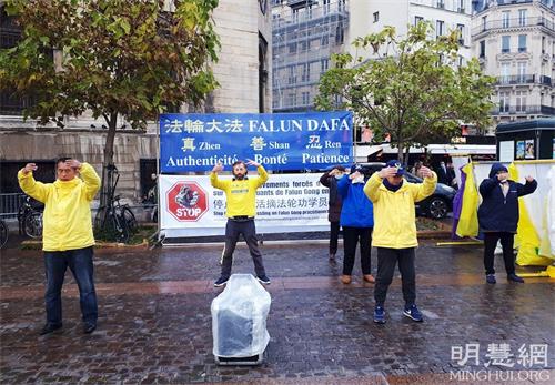 '图4：二零二一年十一月十三日，在夏特蕾地铁站外，法轮功学员展示法轮功功法。'