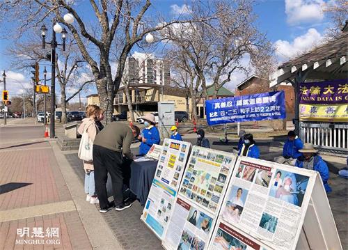 '图1～2：二零二一年四月二十四日，加拿大埃德蒙顿部份法轮大法学员在威尔伯特·麦金太尔博士公园传播真相，纪念四·二五和平上访二十二周年。了解真相后的市民签名反对中共迫害法轮功。'