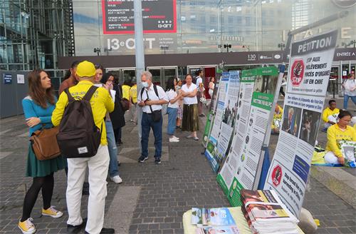 图3～5：人们观看展板，向法轮功学员了解真相。