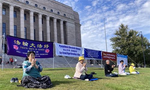 图1：学员们在国会前悬挂“法轮大法好”、“制止中共 活摘器官”、“解体中共 停止迫害” 等横幅